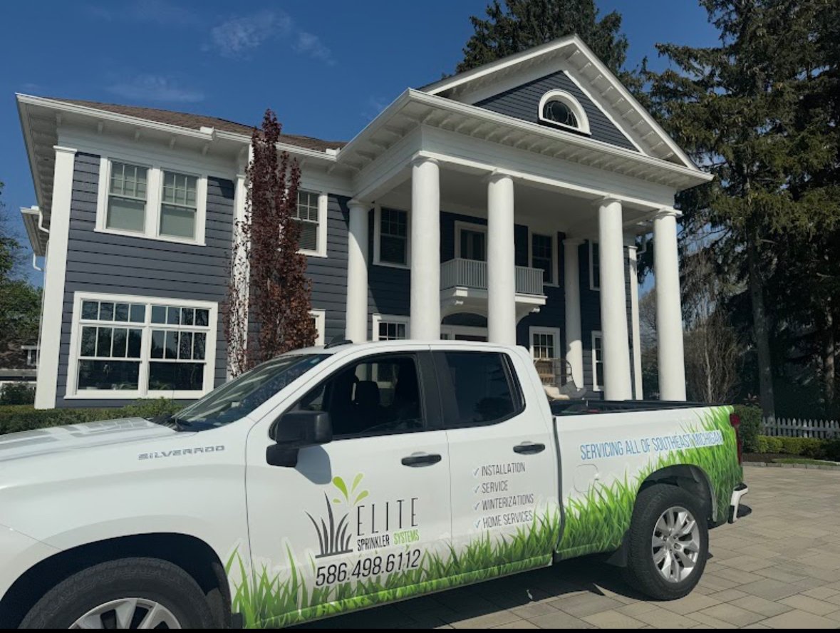 Elite Sprinkler Systems service truck in front of a luxury colonial home in Metro Detroit, Michigan.